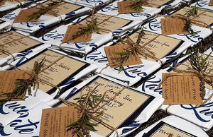 Custom organic cotton tea towel wedding invitations with personalised design, twine wrap, native Australian flora, and kraft card details by Expressions Tea Towels Australia.