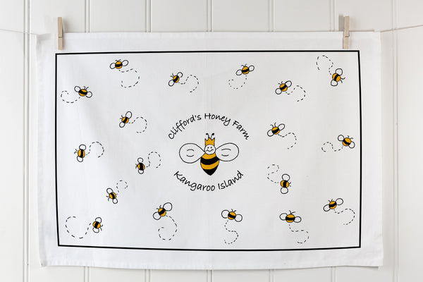 White organic cotton tea towel with bee pattern and custom branding in landscape orientation