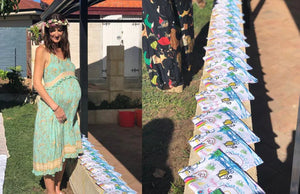 Custom printed organic cotton tea towel featuring a child’s family drawing for a baby shower gift, displayed on a wooden table.