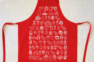 Red custom screen printed apron designed by Coles Meat Team, printed on organic cotton with team member illustrations.