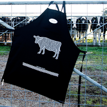 Expressions Tea Towels customised black apron with cow print on farm gate