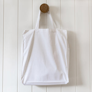 Blank white cotton tote bag hanging on wooden hook – ready for custom screen printing