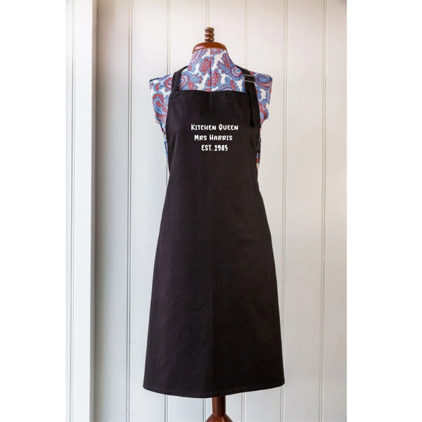 Black apron with text on a mannequin against a white wall