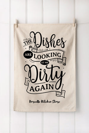 Natural cotton towel with black kitchen text hanging on a white wooden panel wall
