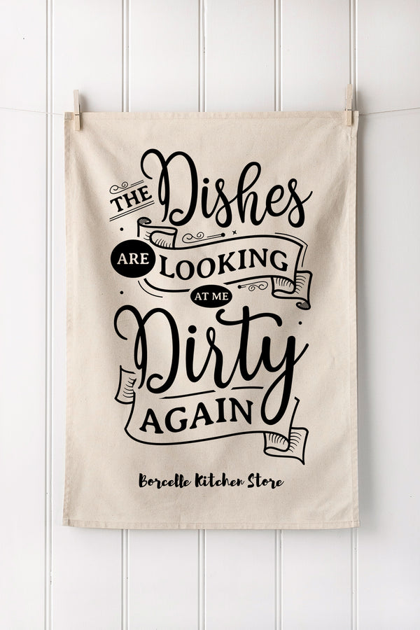 Natural cotton towel with black kitchen text hanging on a white wooden panel wall