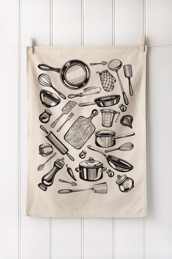 Kitchen tea towel with black illustrations of cooking utensils on a white wooden background